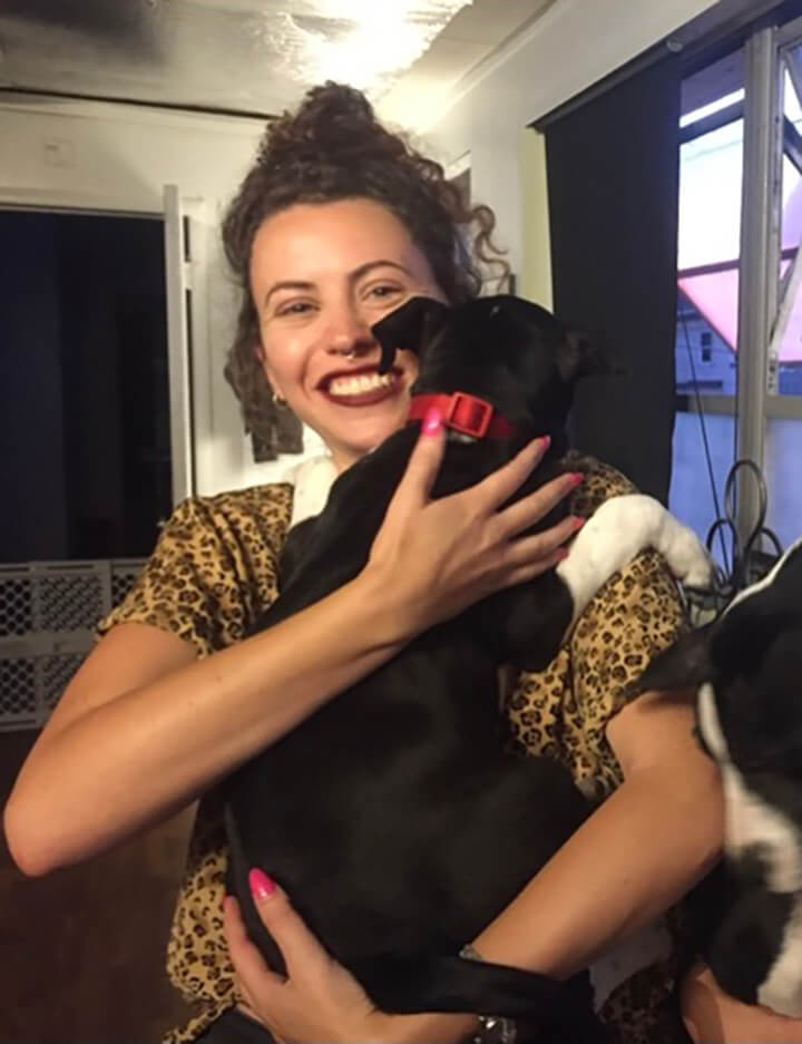 Image of white woman holding a black puppy