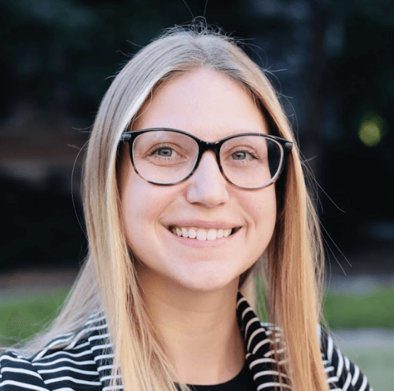 image of white woman with blond hair wearing dark rimmed glasses