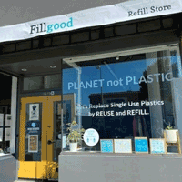 Sunny storefront of FillGood.co, Planet not Plastic written on window