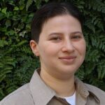 Cristina Cabrera, Administrative Coordinator, smiling with green plants in background